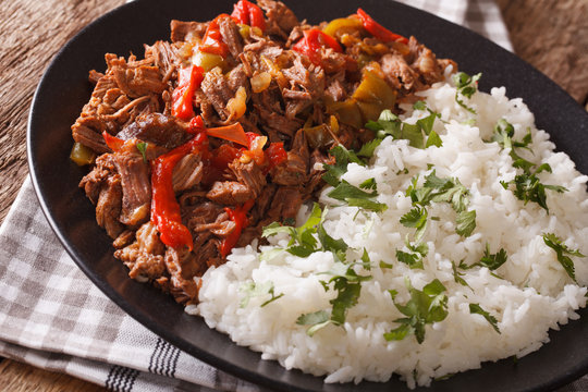 ropa vieja: beef stew in tomato sauce with vegetables and rice garnish macro. horizontal
