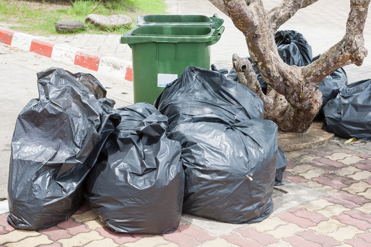 the green bin and Black garbage bags