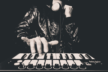 professional musician or DJ hand on studio keyboard synthesizer, B&W isolated on black for dance ,...