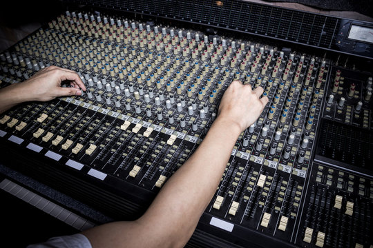hands of sound engineer working on recording studio mixer