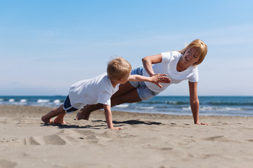 Shot of young mother with her son working out on the beach