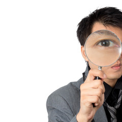 Asian man eye look thru a magnifier, isolated on white