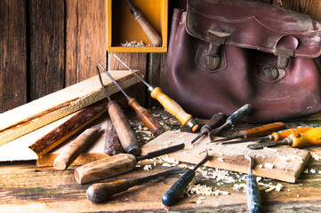 Chisels and carved piece of wood in traditional carpenter worksh