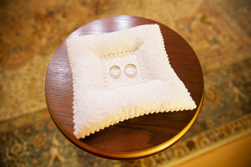 Gold wedding rings on the pillow in the registry office