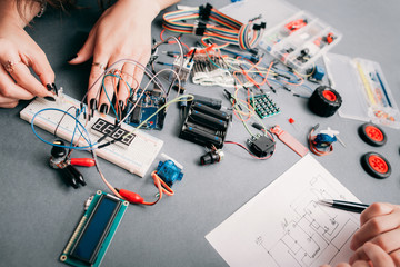 Electronics engineering according to scheme. Electricians creating electronic construction on...