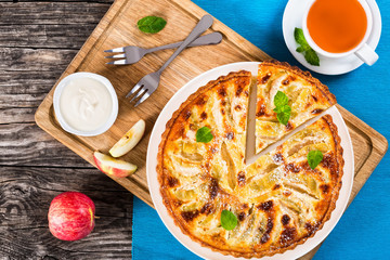 Apple pie sprinkled with icing sugar decorated with mint leaves