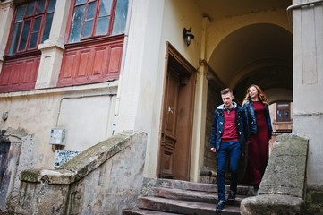 Fototapeta na wymiar Young beautiful stylish fashion couple in a red dress in love story at the old city