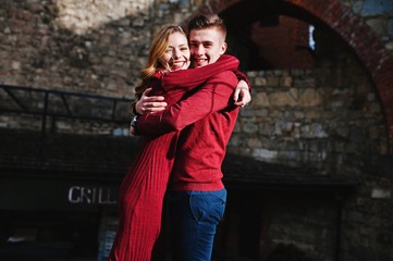 Young beautiful stylish fashion couple in a red dress in love story at the old city