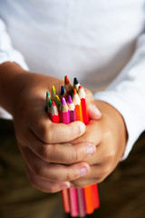 Colored pencils in children's hands, sharpened . Macro