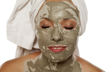 beautiful woman with a mud mask on her face