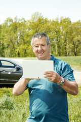 Man with Tablet PC and car