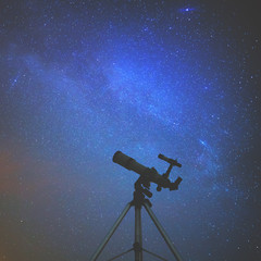 Silhouette of a telescope with starry skies. 