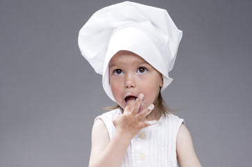 Funny Lovely Cute Caucasian Girl Posing as Cook. Against Gray Background