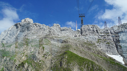 Naklejka na ściany i meble Funkturm auf dem Gipfel des Säntis in der Schweiz, steile Felswände im Alpsteinmassiv, blauer Himmel und weiße Wolken/Funkturm auf dem Säntis
