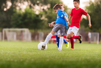Boys playing football soccer game on sports field © Dusan Kostic