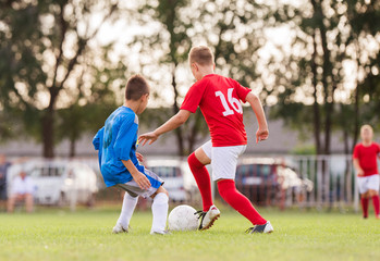 Boys playing football soccer game on sports field
