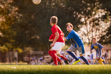Obraz premium Boys playing football soccer game on sports field