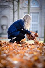 Frau im Park sammlt herbstblääter