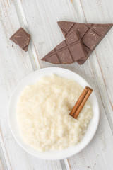 overhead shot pile of rice pudding on porcelain plate, on wood