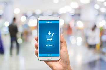 Female hands using smart phone for online shopping on Background blur mall ,Mobile e-commerce business concept.
