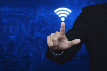 Businessman pressing wi-fi icon over map and city background, Te