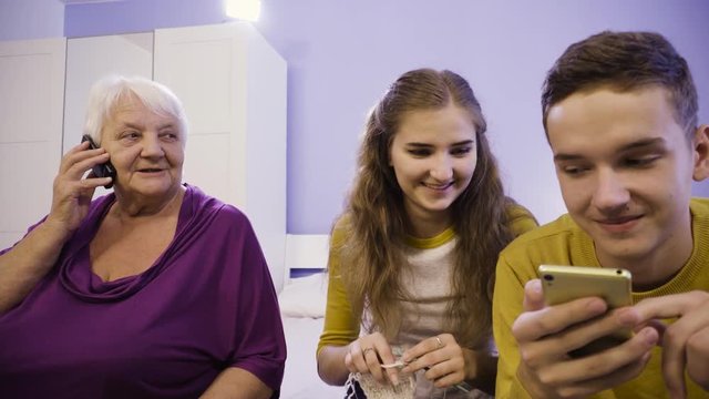 The Woman Knits On The Needles, The Guy With The Smartphone Online.