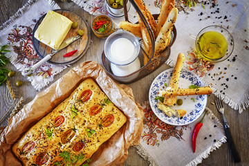 Traditional focaccia with tomatoes and bread sticks.