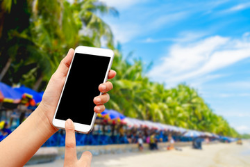 Woman's hand holding a smart phone  on the seaside Background