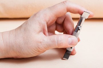 hand of craftsman with Swivel knife on leather