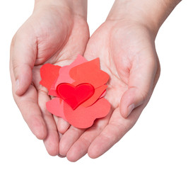 Obraz premium red heart above pile of paper hearts on male palms