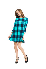 Young cute girl in a checkered dress isolated on white background.
