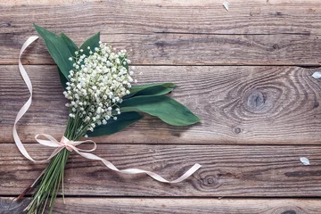 Photo sur Aluminium Muguet Bouquet of lily of the valley on the old wooden background. Plac