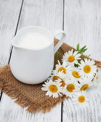 Obraz na płótnie Canvas jug with milk and chamomile flower