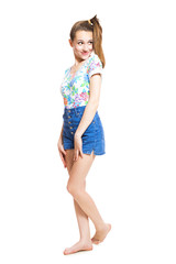 Naklejka premium Funny young teen girl in a bright blouse and shorts posing in studio isolated on white background.