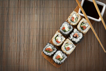 Delicious sushi rolls on table