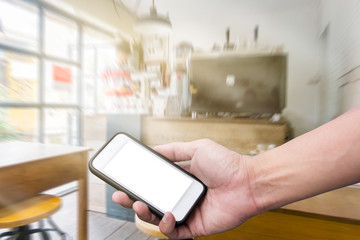Hand holding smart phone over cafe background