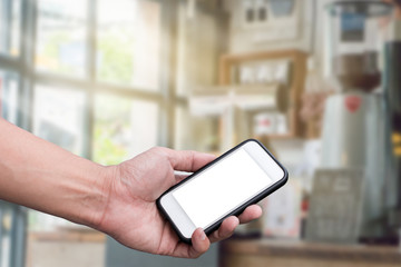 Hand holding smart phone over cafe background