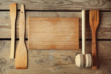 Empty cutting board and kitchen tools on wooden planks background