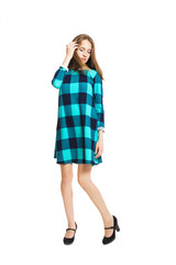 Young cute girl in a checkered dress isolated on white background.