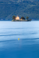 blue morning with lonely church on the island in lake