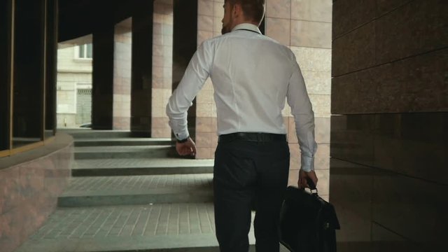 going business man holding brief case over wite in street