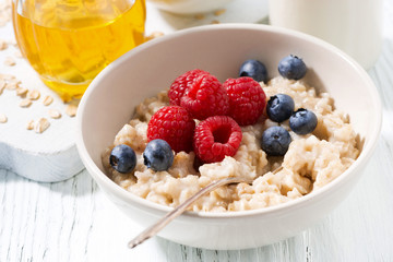 delicious homemade oatmeal with berries for breakfast, closeup