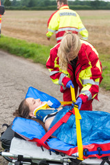 Notfallsanitäterin versorgt eine Patientin auf einer Vakuummatratze