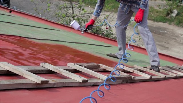 man paints the roof/paint spray guns roof