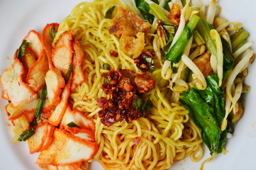 Chinese egg noodle with barbecue pork and vegetable topping chili paste on plate