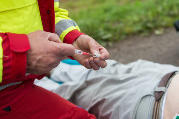 Notarzt zieht eine Spritze mit Medikamenten auf