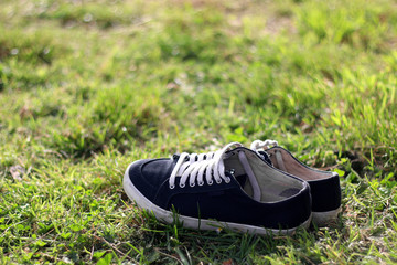 Black sneakers in the grass. Selective focus.