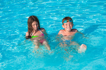 Cildren playing and splashing water in swimming pool