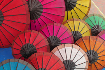 Many colorful opened umbrellas made of paper and wood
