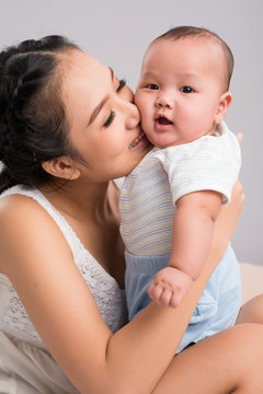 Portrait of young mother kissing her baby boy